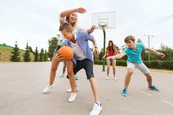 Группа счастливых подростков, играющих в баскетбол — стоковое фото