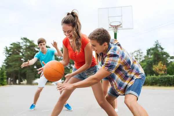 Group of happy teenagers playing basketball — Stock Photo, Image
