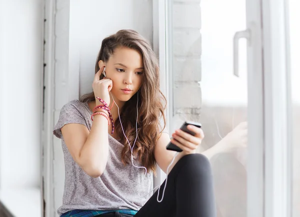 Menina adolescente com smartphone e fones de ouvido — Fotografia de Stock