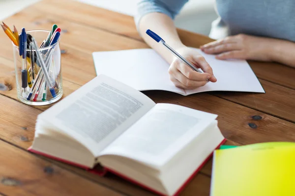 Närbild på student med bok och bärbar dator hemma — Stockfoto