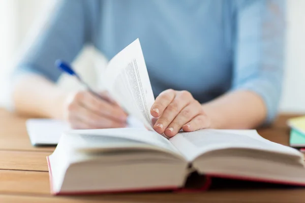 Close up van student met boek en laptop thuis — Stockfoto