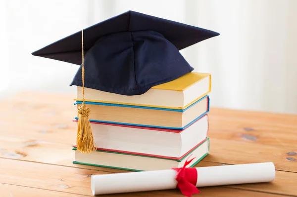 Close up van boeken met diploma en mortarboard — Stockfoto