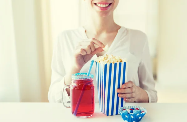 Mujer comiendo palomitas de maíz con bebida en tarro de cristal de albañil — Foto de Stock