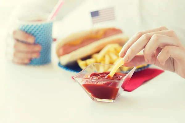 Primer plano de las manos de la mujer comiendo en la comida americana —  Fotos de Stock