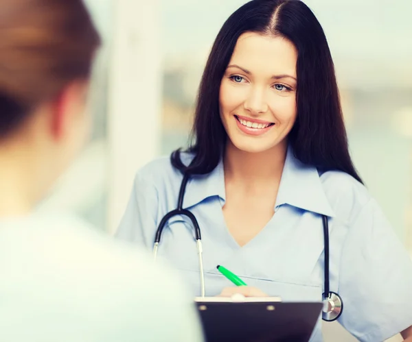 Leende läkare eller sjuksköterska med patienten — Stockfoto