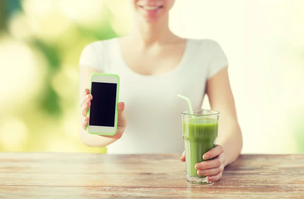 Close up of woman with smartphone and green juice — Stock Photo, Image