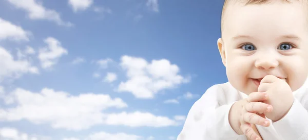 Szczęśliwy twarz dziecko nad błękitne niebo tło — Zdjęcie stockowe