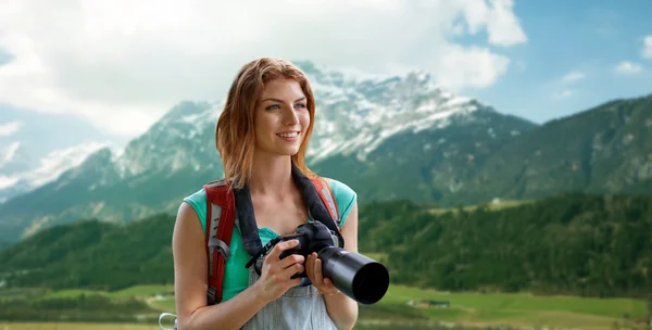 Женщина с рюкзаком и камерой над горами — стоковое фото