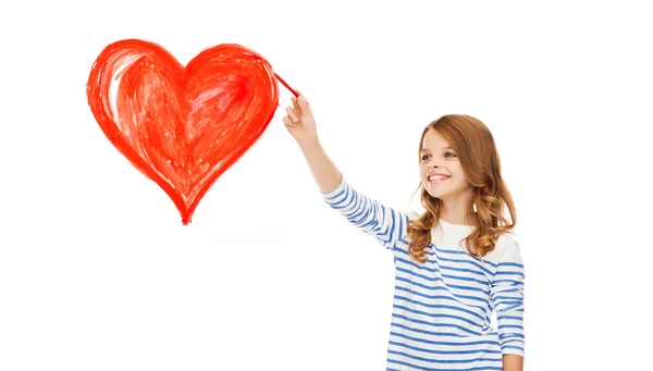 Girl drawing big red heart in the air — Stock Photo, Image