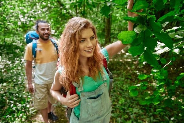 Feliz pareja con mochilas senderismo en el bosque — Foto de Stock