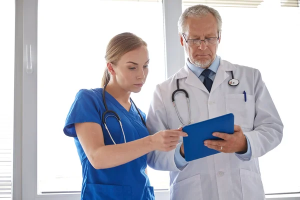 Médico sênior e enfermeira com tablet pc no hospital — Fotografia de Stock
