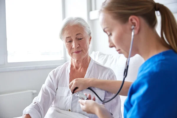 Медсестра зі стетоскопом і старшою жінкою в клініці — стокове фото