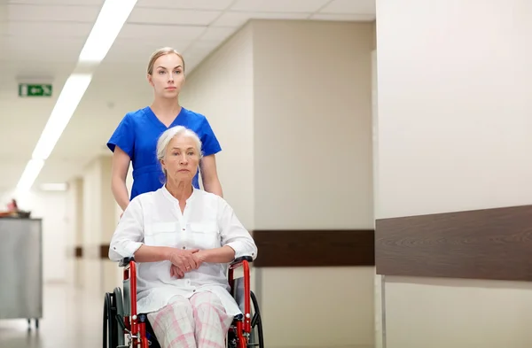 Enfermera con mujer mayor en silla de ruedas en el hospital —  Fotos de Stock
