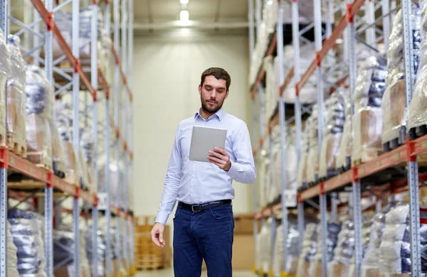 Geschäftsmann mit Tablet-PC im Lager — Stockfoto