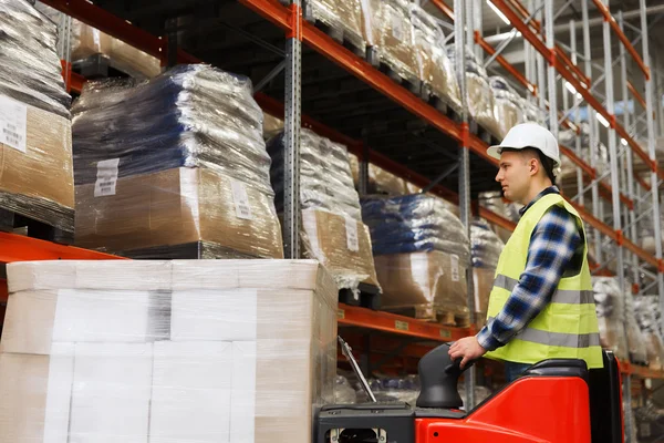 Man on forklift loading cargo at warehouse — Stock Photo, Image