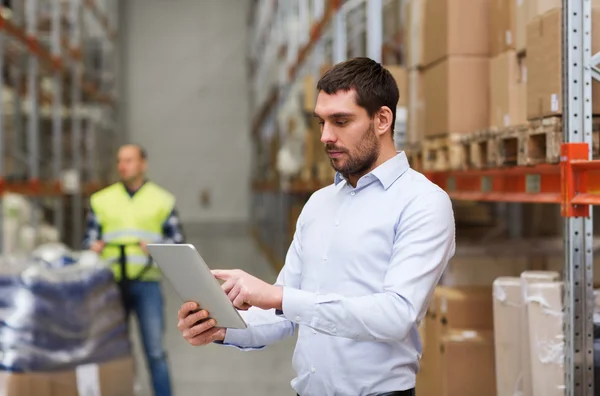 Businessman with tablet pc at warehouse — Stock Photo, Image