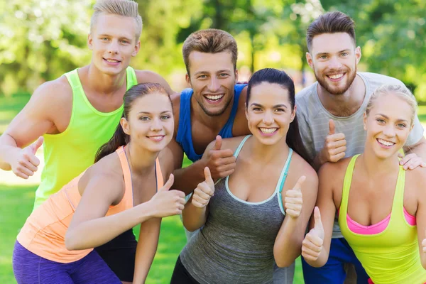 Grupp glada sportiga vänner visar tummen upp — Stockfoto