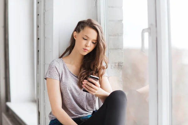 Smutný to dospívající dívka s smartphone SMS — Stock fotografie