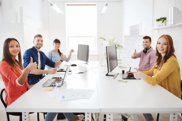 Kreativteam mit Computern, die Daumen nach oben zeigen — Stockfoto