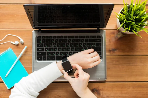 Primo piano della donna con orologio intelligente e laptop — Foto Stock