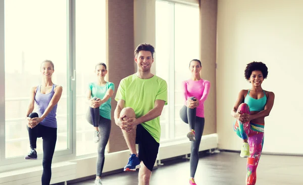 Groep lachende mensen trainen in de sportschool — Stockfoto