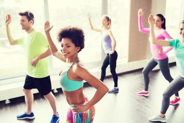 Groupe de personnes souriantes dansant en salle de gym ou studio — Photo