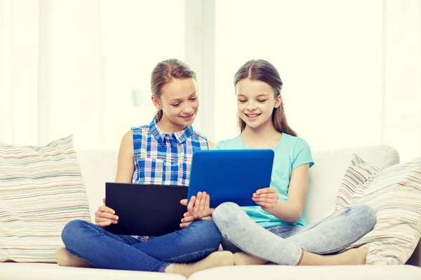 Счастливые девочки с планшетным компьютером, сидящие на диване дома — стоковое фото