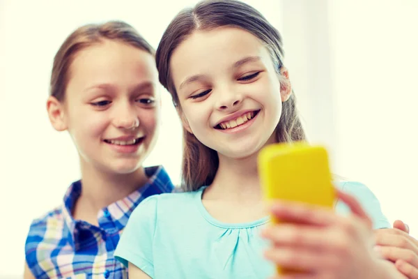 Happy girls with smartphone taking selfie at home — Stock Photo, Image