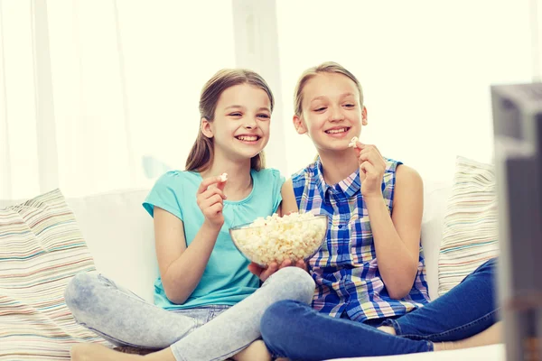 Meninas felizes com pipocas assistindo tv em casa — Fotografia de Stock