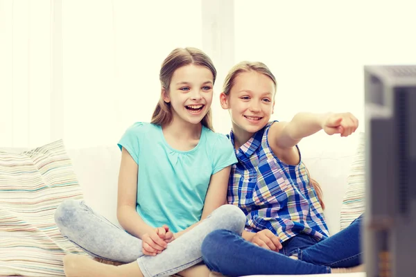 Duas meninas pequenas felizes assistindo tv em casa — Fotografia de Stock