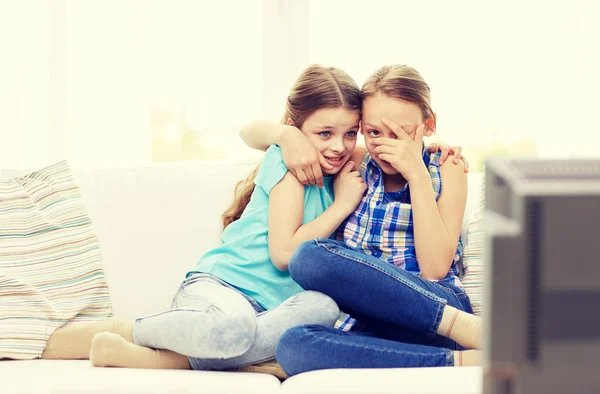 Scared little girls watching horror on tv at home — Stock Photo, Image