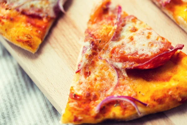 Primer plano de rebanada de pizza casera en la mesa de madera — Foto de Stock