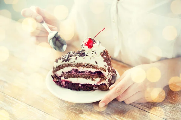 Primer plano de la mujer comiendo pastel de cereza de chocolate — Foto de Stock