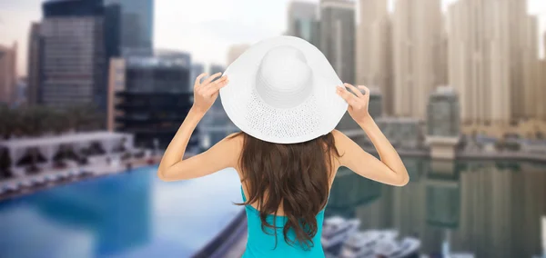 Woman in swimsuit and sun hat from back over city — Stock Photo, Image