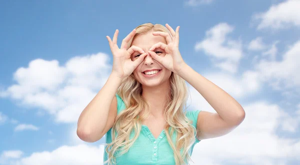 Jeune femme regardant à travers des lunettes de doigt — Photo