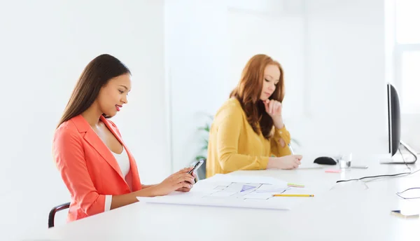 Mujer de negocios mensajes de texto en el teléfono inteligente en la oficina — Foto de Stock