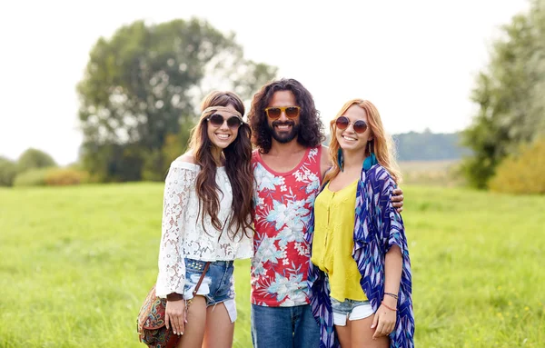 Sonriendo jóvenes amigos hippies en el campo verde — Foto de Stock