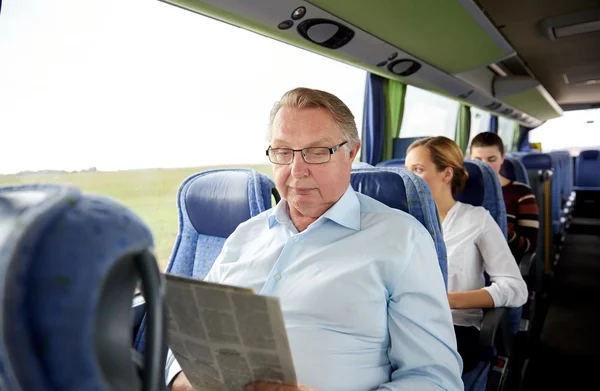 Lycklig senior man läsa tidningen i resa buss — Stockfoto