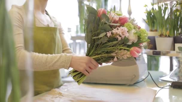 Floristería envolviendo flores en papel en floristería — Vídeo de stock