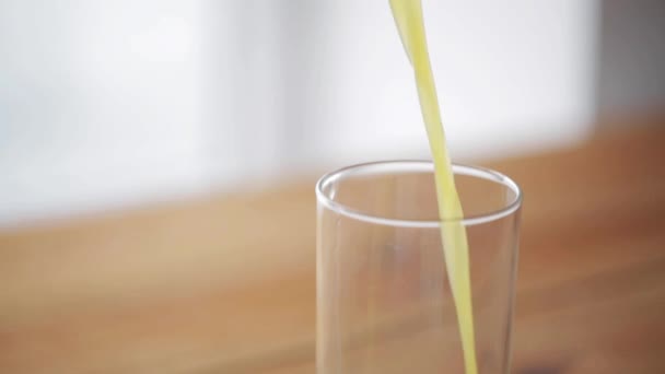 橙汁倒入木制桌上的玻璃杯 — 图库视频影像