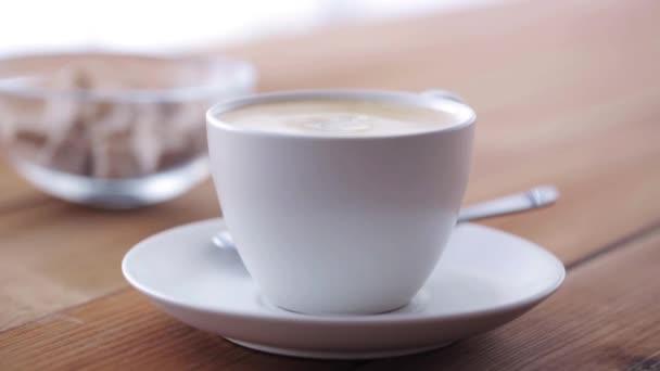 Crème verser dans une tasse à café sur une table en bois — Video