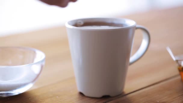Χέρι προσθήκη ζάχαρης στο φλιτζάνι τσάι ή καφέ — Αρχείο Βίντεο