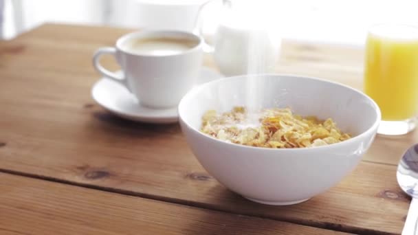 Sugar pouring to corn flakes on wooden table — Stock Video