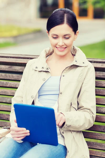 Donna con tablet pc seduta su panca nel parco — Foto Stock