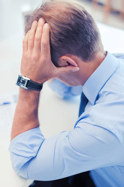 Stressad affärsman med papper på jobbet — Stockfoto