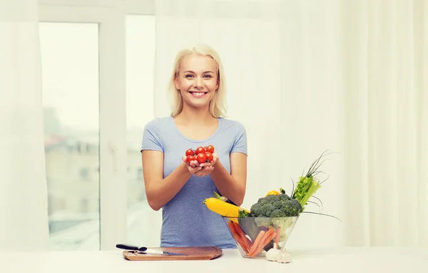 若い女性が自宅に野菜を料理を笑顔 — ストック写真