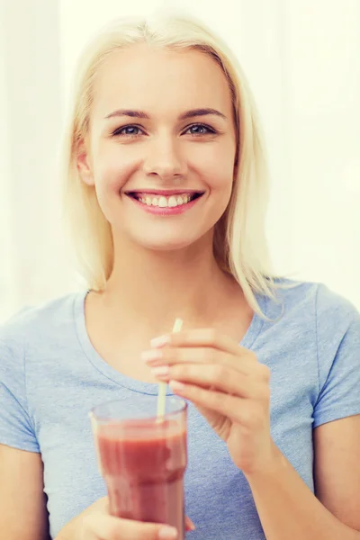 Femme souriante boire du jus ou secouer à la maison — Photo