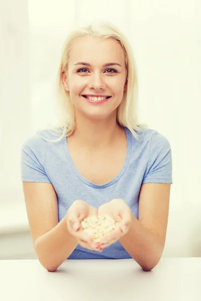 Mujer feliz sosteniendo pastillas o cápsulas en casa — Foto de Stock