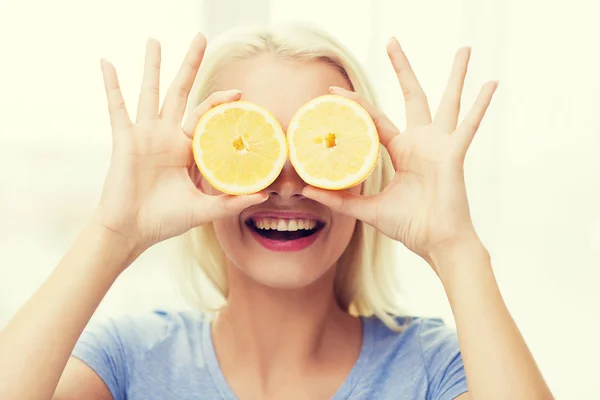 Happy woman having fun covering eyes with lemon — Zdjęcie stockowe