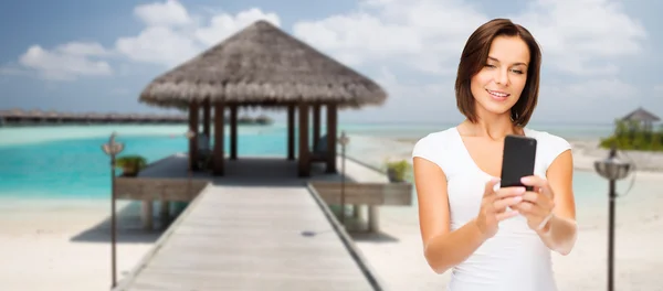 Щаслива жінка бере селфі по смартфону над пляжем — стокове фото